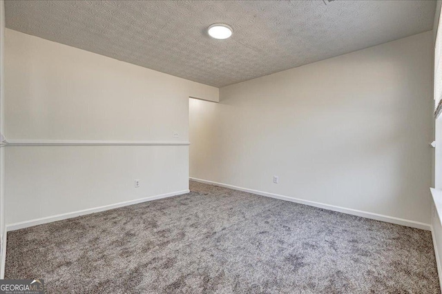 unfurnished room with carpet flooring, a textured ceiling, and baseboards