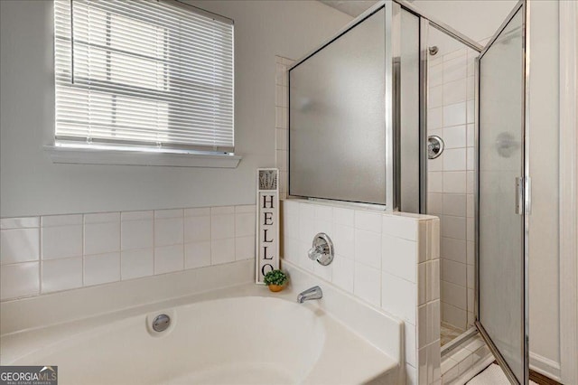 full bath featuring a stall shower and a garden tub