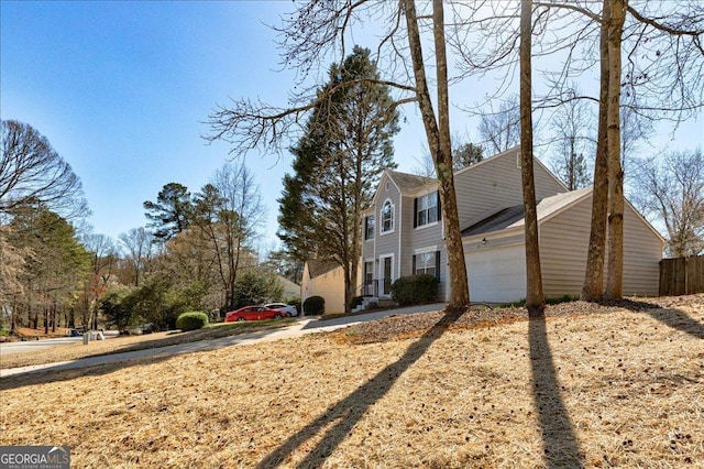 view of side of home with a garage and fence