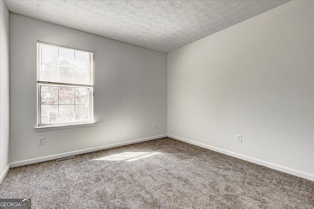 unfurnished room featuring a textured ceiling, carpet floors, plenty of natural light, and baseboards