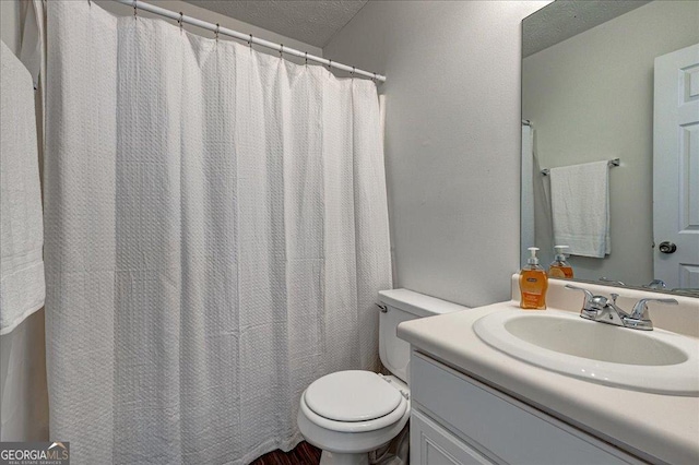 full bathroom featuring vanity, toilet, and a textured ceiling