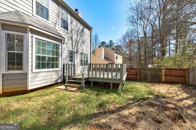 exterior space featuring fence, a lawn, and a wooden deck