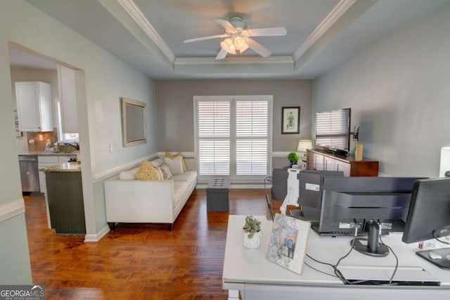 office area with ceiling fan, baseboards, dark wood-style floors, a raised ceiling, and crown molding