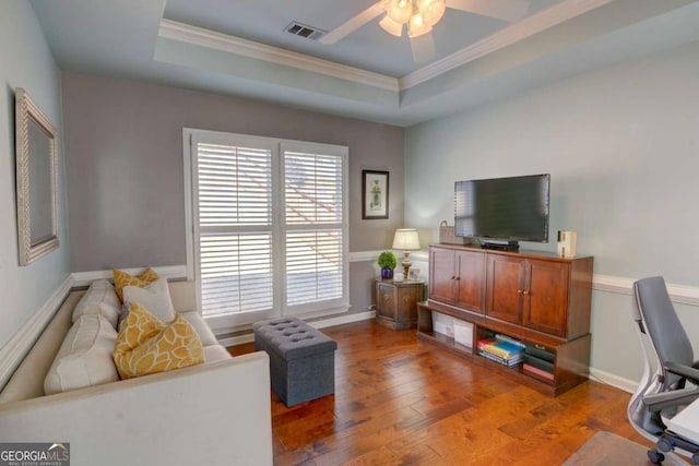 office area with ornamental molding, a tray ceiling, light wood-style flooring, and visible vents