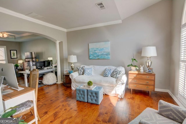 living area featuring arched walkways, visible vents, a healthy amount of sunlight, hardwood / wood-style floors, and ornate columns