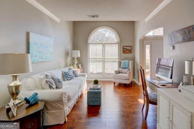 living area with dark wood-style floors, arched walkways, visible vents, and ornamental molding