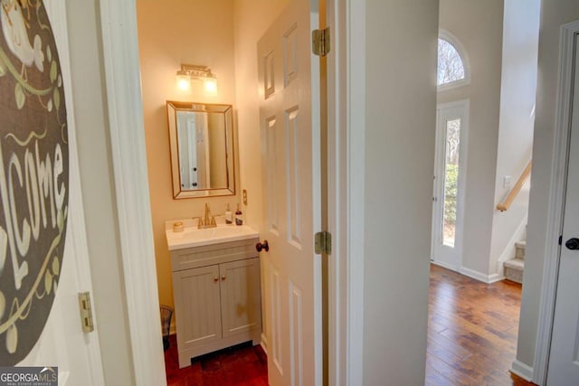 bathroom featuring baseboards, wood finished floors, and vanity