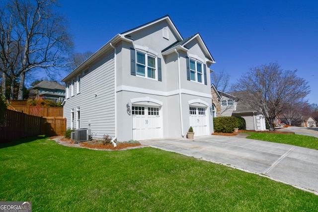 view of front of home with an attached garage, fence, concrete driveway, stucco siding, and a front lawn