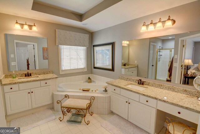 full bath with two vanities, a stall shower, a garden tub, and a sink