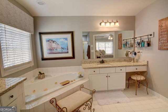 full bath featuring tile patterned flooring, baseboards, vanity, and a tub with jets