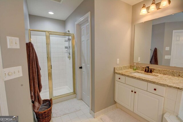 full bath featuring a stall shower, baseboards, and vanity