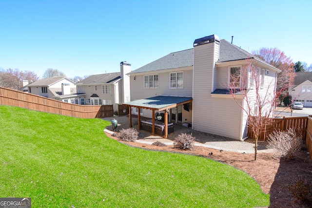 rear view of house with a lawn, a patio, a fenced backyard, a chimney, and a residential view