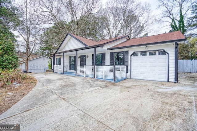 single story home featuring a garage, fence, a porch, and concrete driveway