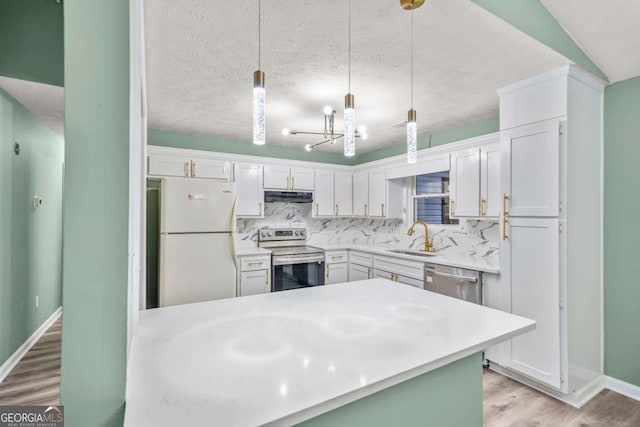 kitchen featuring decorative backsplash, stainless steel appliances, light countertops, under cabinet range hood, and a sink