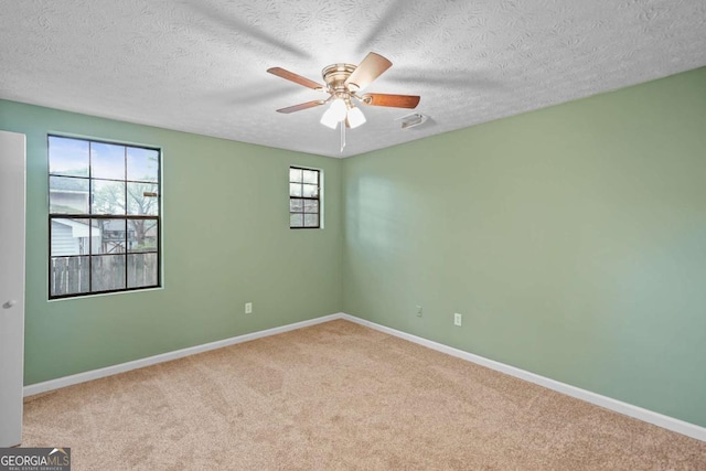 carpeted empty room featuring ceiling fan, baseboards, and a textured ceiling