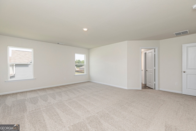 carpeted empty room with visible vents and baseboards