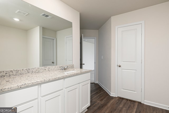 bathroom featuring vanity, wood finished floors, visible vents, and baseboards