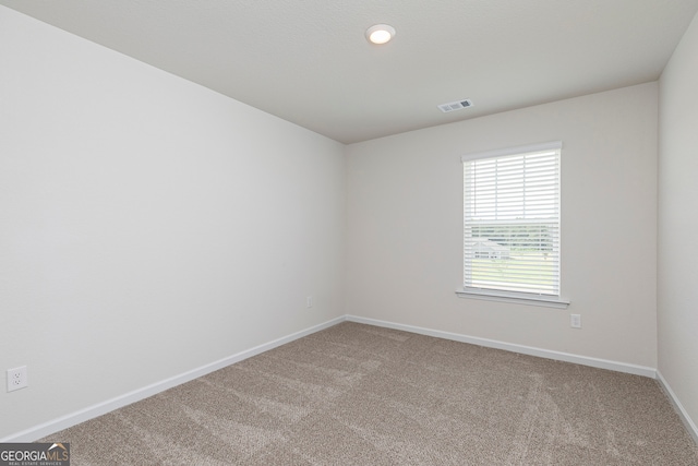 carpeted spare room featuring recessed lighting, visible vents, and baseboards