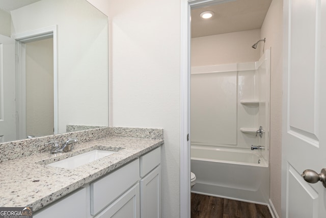 full bathroom with shower / bathtub combination, vanity, toilet, and wood finished floors