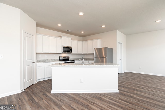 kitchen featuring stainless steel appliances, white cabinetry, an island with sink, and dark wood-style floors