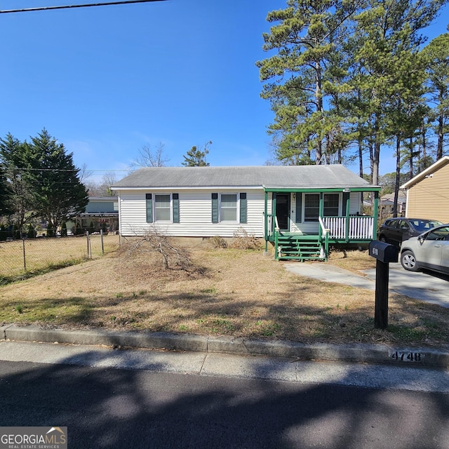 view of front of home featuring a porch, crawl space, and fence