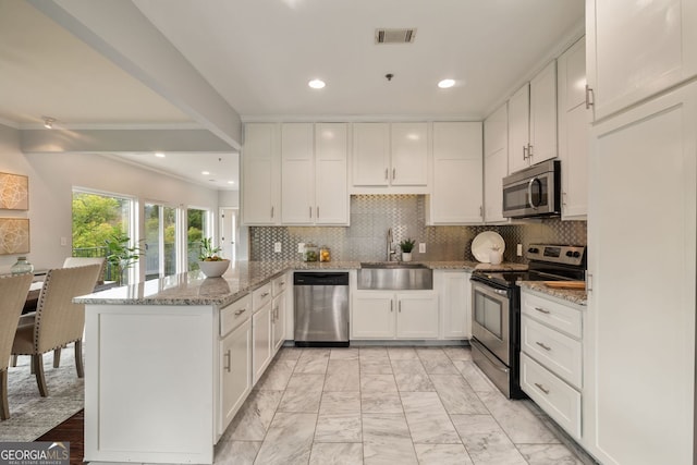 kitchen with visible vents, appliances with stainless steel finishes, a peninsula, marble finish floor, and a sink