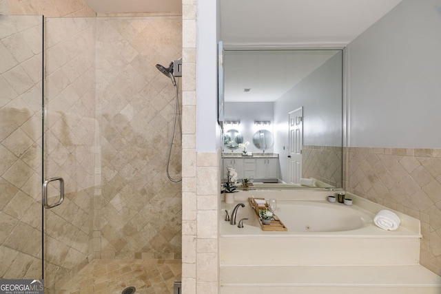 bathroom with a jetted tub, vanity, and a stall shower