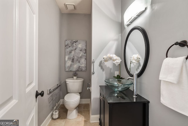 bathroom with visible vents, toilet, vanity, baseboards, and tile patterned floors