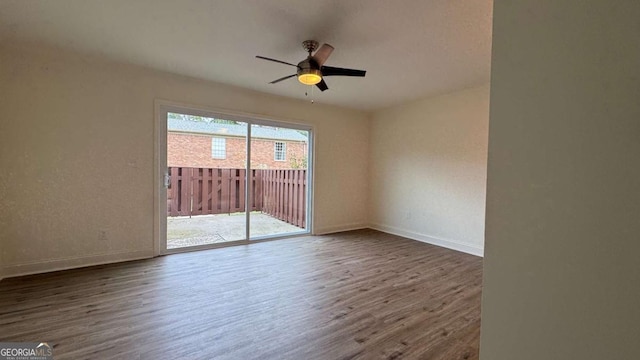 empty room with ceiling fan, baseboards, and wood finished floors