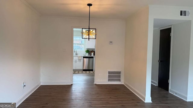 unfurnished dining area with dark wood finished floors, visible vents, crown molding, and baseboards