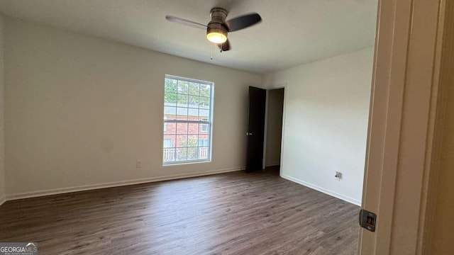 empty room featuring baseboards, ceiling fan, and wood finished floors