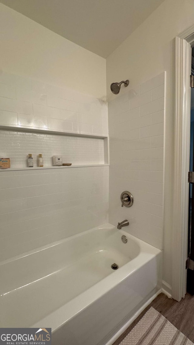 bathroom featuring tub / shower combination and wood finished floors