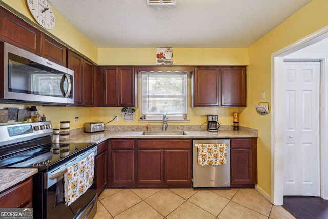 kitchen with light tile patterned floors, visible vents, appliances with stainless steel finishes, a sink, and a textured ceiling