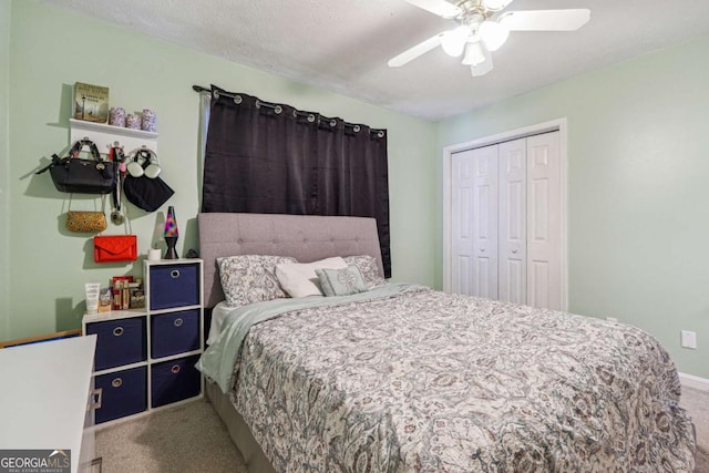 carpeted bedroom with ceiling fan, a textured ceiling, baseboards, and a closet