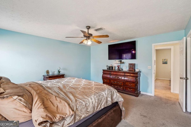 bedroom featuring baseboards, visible vents, a textured ceiling, and light colored carpet