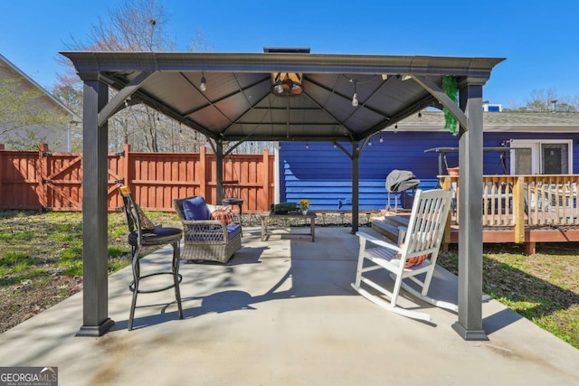 view of patio / terrace with fence, a wooden deck, and a gazebo