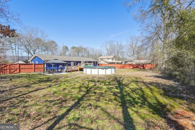 view of yard featuring a gazebo, a fenced backyard, and a fenced in pool