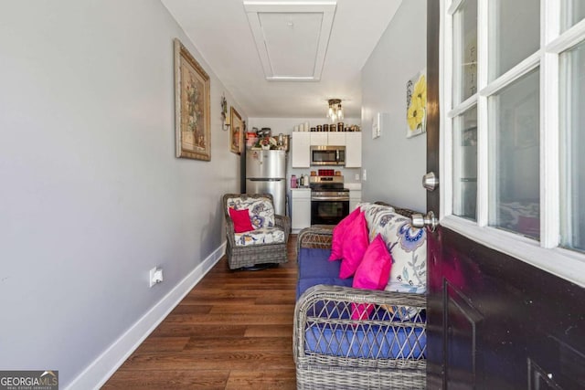 sitting room featuring dark wood-style floors, attic access, and baseboards