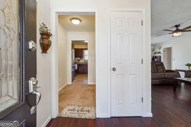 hallway featuring hardwood / wood-style flooring, baseboards, and a textured ceiling