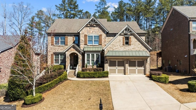 craftsman-style house with central air condition unit, driveway, a standing seam roof, metal roof, and a garage