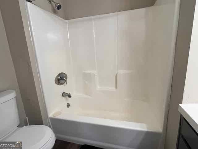 bathroom featuring toilet, shower / washtub combination, and vanity