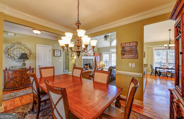 62 Crooked Branch Dr, Clayton, GA 30525 - dining room featuring a chandelier, ornamental molding, wood finished floors, a stone fireplace, and a ceiling fan
