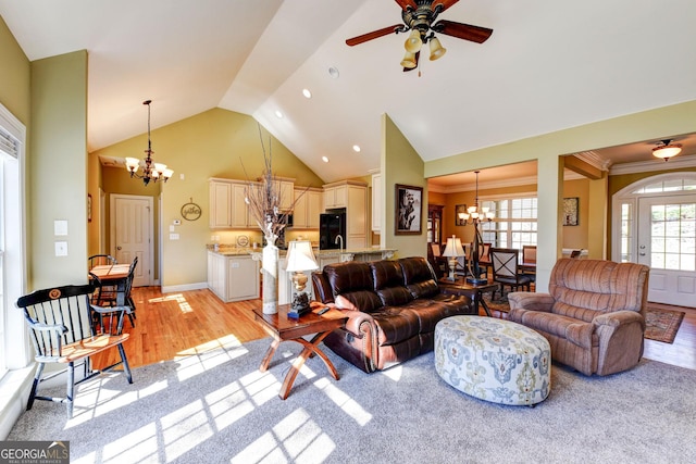 living area with a chandelier, ceiling fan, light wood-style floors, high vaulted ceiling, and recessed lighting