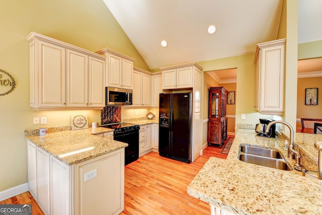 kitchen featuring black appliances, a peninsula, a sink, cream cabinets, and crown molding