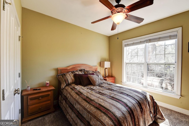 bedroom featuring dark colored carpet, ceiling fan, and baseboards