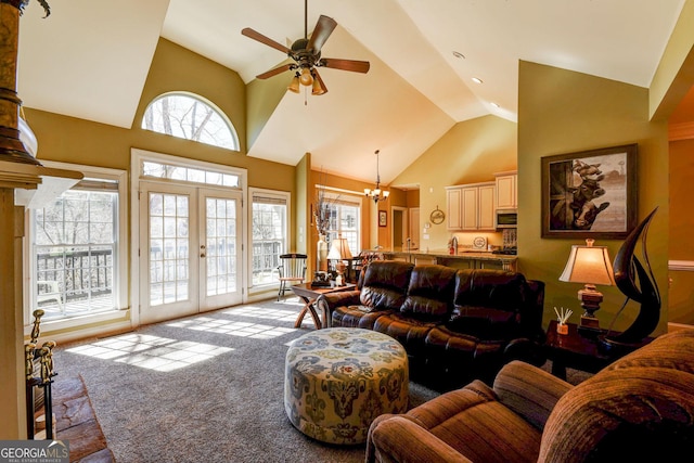 living room featuring high vaulted ceiling, french doors, light colored carpet, and ceiling fan with notable chandelier