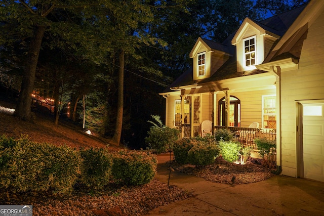 view of side of property featuring covered porch and a garage