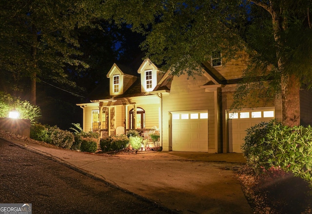 cape cod house featuring driveway and a porch
