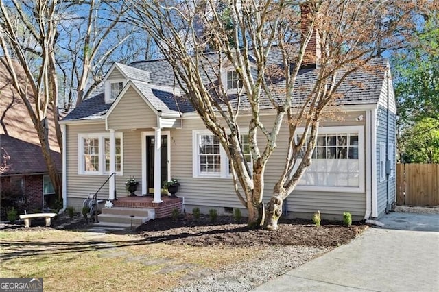 view of front of house featuring a shingled roof, crawl space, and fence