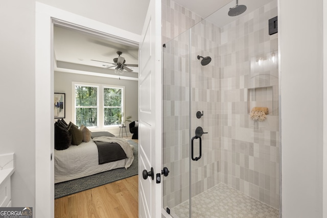 ensuite bathroom featuring wood finished floors, a stall shower, and connected bathroom